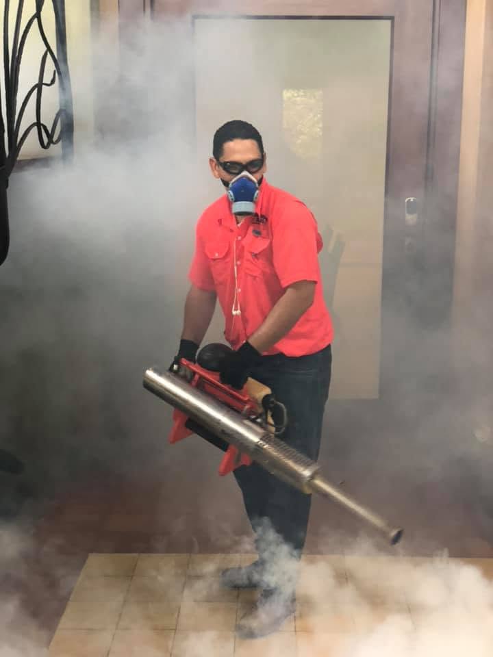 Tecnico fumigando con equipo profesional